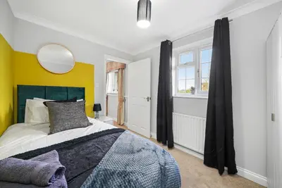 a bedroom with a large bed and a mirror at Detached 6 Bedroom Cambridgeshire Abode - Pets in Whittlesford