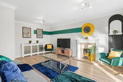 a living room with a couch and a fireplace at Detached 6 Bedroom Cambridgeshire Abode - Pets in Whittlesford