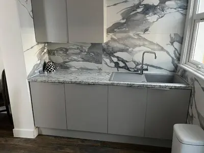 a kitchen with white cabinets and a sink at Southend Luxe Retreat in Southend-on-Sea