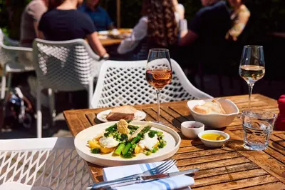 a table with a plate of food and a glass of wine at The Sun Inn in Dedham