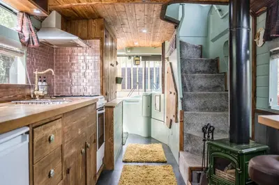 a kitchen with a staircase and a stove at The Bus Stop, Thornham Magna in Thornham Magna
