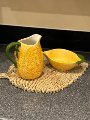 a yellow pitcher and a bowl on a table at Cosy central hideout in Ware