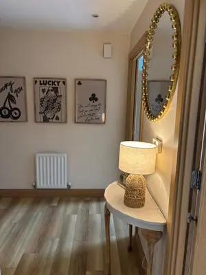 a room with a table with a lamp and a mirror at Cosy central hideout in Ware