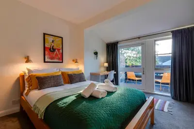 a bedroom with a large bed and a large window at Modern and Stylish Townhouse in City Centre Pass the Keys in Cambridge