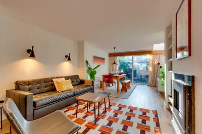a living room with a leather couch and a table at Modern and Stylish Townhouse in City Centre Pass the Keys in Cambridge