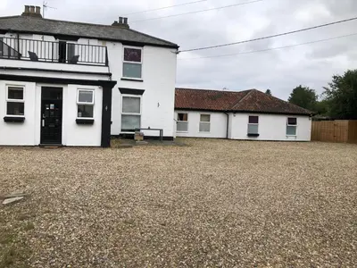 a white house with a gravel driveway at OYO Watton Vibe Hotel in Watton