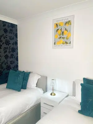 a bedroom with two beds and a picture on the wall at Relaxed Leigh-on-Sea Escape, Family-Friendly & Contractor Stays in Hockley