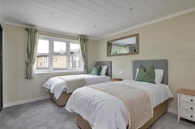 a bedroom with two beds and a window at Finest Retreats - Cambridge Luxury Lodge