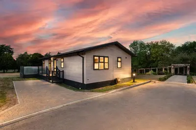 a small house sitting on the side of a road at Finest Retreats - Cambridge Luxury Lodge