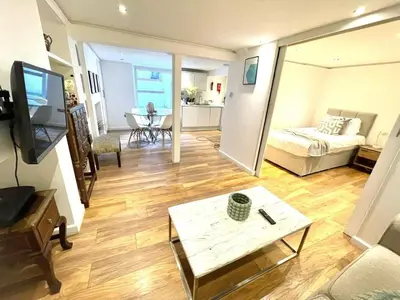 a living room with a bed and a table at Historical Building - Cozy Basement Apartment- Central Location in Cambridge
