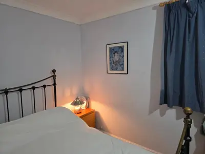 a bedroom with a bed and a blue curtain at Stay Near Colchester twn centre3 in Hythe