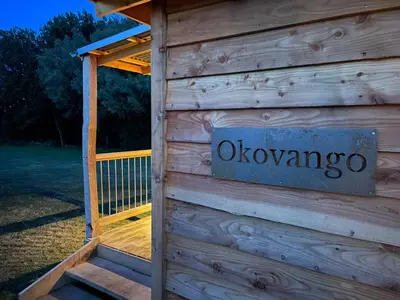 a sign on the side of a wooden building at Okovango Cabin in Holton