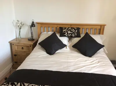 a bed with black and white pillows on it at Beightons Bed and Breakfast in Bury Saint Edmunds