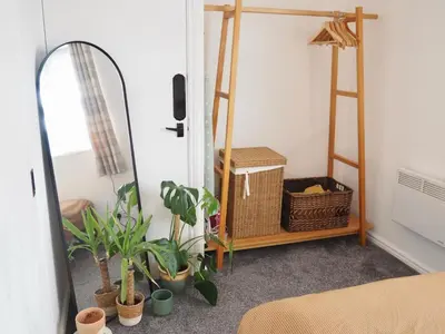 a bedroom with plants and a mirror and a shelf at Cosy Room in Debenham in Debenham