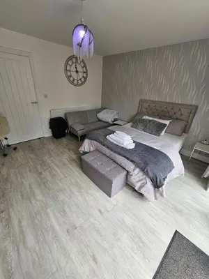 a bedroom with a large bed and a couch at Bright spacious room in Manningtree in Manningtree