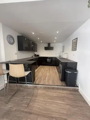 a kitchen with a table and chairs in a room at Stylish 3 bed spacious flat in Brentwood