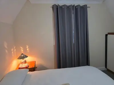 a bedroom with a bed and a blue curtain at Stay Near Colchester twn centre4 in Colchester