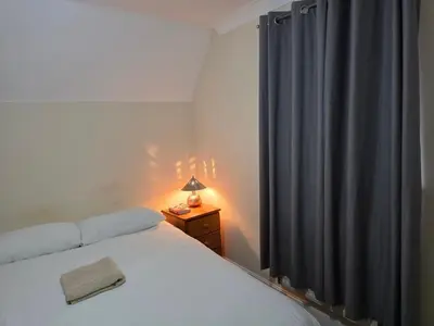 a bedroom with a bed and a blue curtain at Stay Near Colchester twn centre4 in Colchester