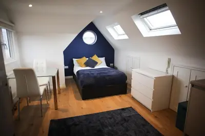 a bedroom with a bed and a desk with a window at Cosy Loft Retreat off Vibrant Mill Road just minutes from station in Cambridge