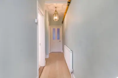 a hallway with a white door and a chandelier at 3 Bed in Aldeburgh oc-f32700 in Aldeburgh