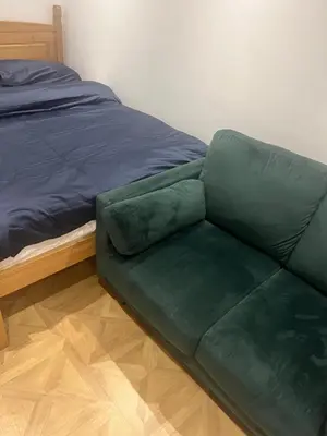 a green couch sitting next to a bed at High street in Toft