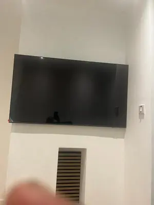 a flat screen tv hanging on a wall at High street in Toft
