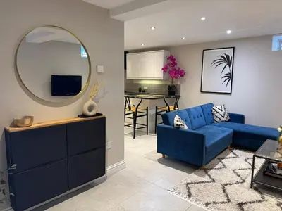 a living room with a blue couch and a mirror at Central Bury Apartment with Private Entrance in Bury Saint Edmunds