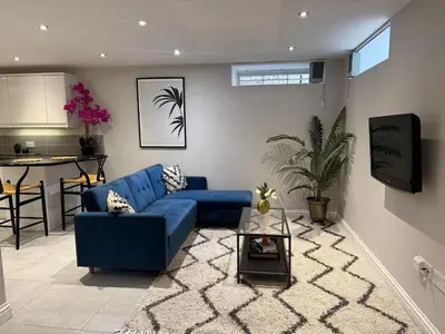 a living room with a blue couch and a table at Central Bury Apartment with Private Entrance in Bury Saint Edmunds
