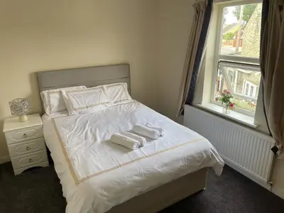 a bedroom with a bed with two towels on it at Gilead Grace House in Littleport