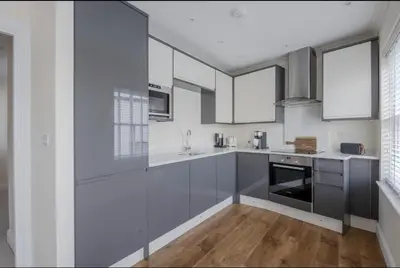 a kitchen with gray cabinets and white appliances at Amazing Abodes in Chelmsford