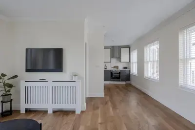 a living room with white walls and a flat screen tv at Amazing Abodes in Chelmsford