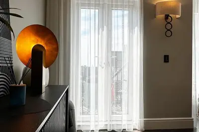 a room with a large window with white curtains at Canewdon Rd Luxury Accommodation in Westcliff On Sea