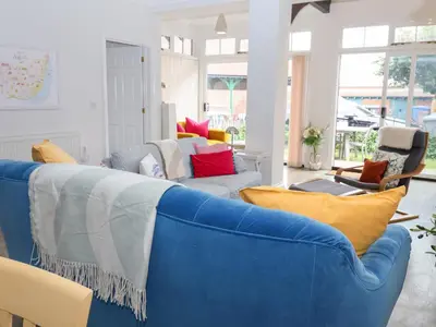 a living room with a blue couch with colorful pillows at Old Felixstowe, Bath Road in Felixstowe