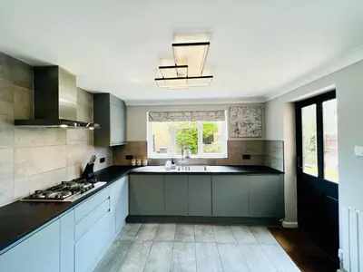 a kitchen with a sink and a stove top oven at Luxury Homely Stay Near City Centre With Parking in Colchester
