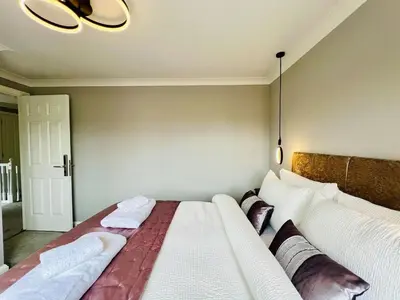 a bedroom with a large bed with two pillows at Luxury Homely Stay Near City Centre With Parking in Colchester