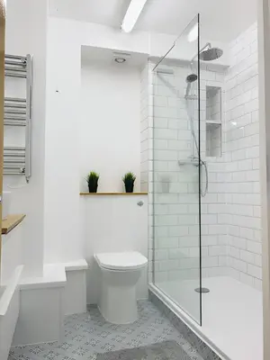 a white bathroom with a toilet and a shower at Spacious 2-Bed Flat in Homerton House in Cambridge