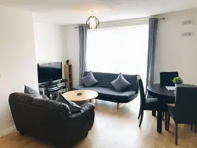 a living room with a couch and a table at Spacious 2-Bed Flat in Homerton House in Cambridge