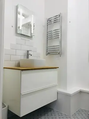 a white bathroom with a sink and a mirror at Spacious 2-Bed Flat in Homerton House in Cambridge