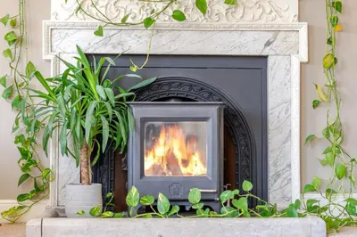 a fireplace in a living room with a fire at 6 Angel Hill, Bury st Edmunds in Bury Saint Edmunds