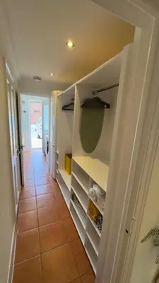a kitchen with white cabinets and a tiled hallway at Peaceful Springfield Studio in Chelmsford