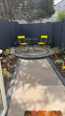 two yellow chairs and a table in a backyard at Peaceful Springfield Studio in Chelmsford