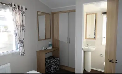 a bathroom with a sink and a toilet and a mirror at Lovely Caravan At Carlton Meres Holiday Park Ref 60034O in Saxmundham