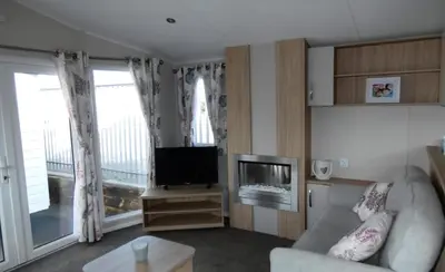 a living room with a couch and a television at Lovely Caravan At Carlton Meres Holiday Park Ref 60034O in Saxmundham