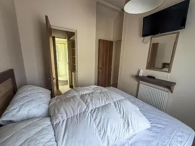 a bedroom with a bed and a television on the wall at Stunning Lodge With Full Sea Views At Coopers Beach Holiday Park Ref 49019S in East Mersea