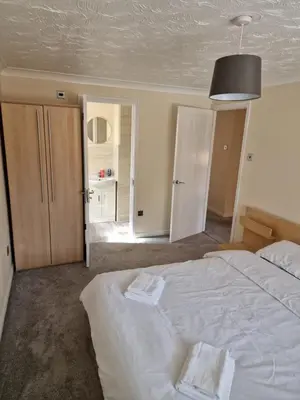 a bedroom with a large white bed with a black ceiling at SK Short Let