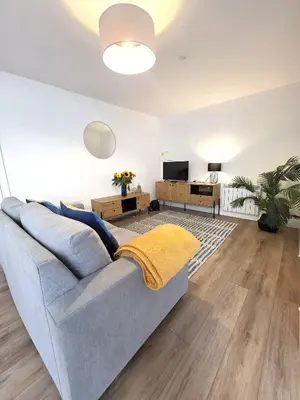 a living room with a couch and a tv at Deluxe One Bed Flat at Dawe Luxury Suites - An Entire Apartment near Ely Cathedral & Train Station - Ideal Gateway to Explore Ely, Cambridge, Norfolk & London - Sleeps up to 4 in Ely