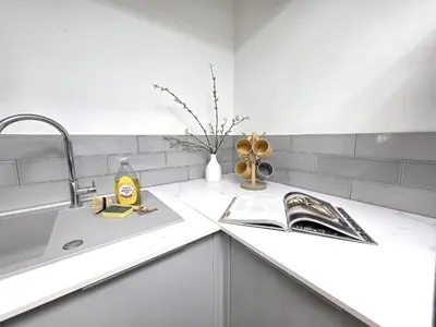 a kitchen counter with a book and a sink at Deluxe One Bed Flat at Dawe Luxury Suites - An Entire Apartment near Ely Cathedral & Train Station - Ideal Gateway to Explore Ely, Cambridge, Norfolk & London - Sleeps up to 4 in Ely