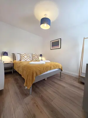a bedroom with a bed with a yellow blanket on it at Cozy One Bed Flat at Dawe Luxury Suites - An Entire Apartment near Ely Cathedral & Train Station - The Perfect Base to Explore Ely, Cambridge, Norfolk & London - 2 Guests Max & Pet Friendly in Ely