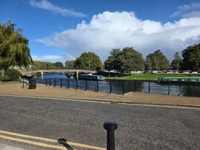 a river with a bridge and boats on the water at Stunning One Bed Flat at Dawe Luxury Suites - An Entire Apartment near Ely Cathedral & Train Station - The Perfect Base to Explore Ely, Cambridge, Norfolk & London - 2 Guests Max in Ely