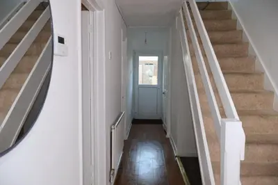 a hallway with stairs leading to a door at Homely three bedroom in Vange